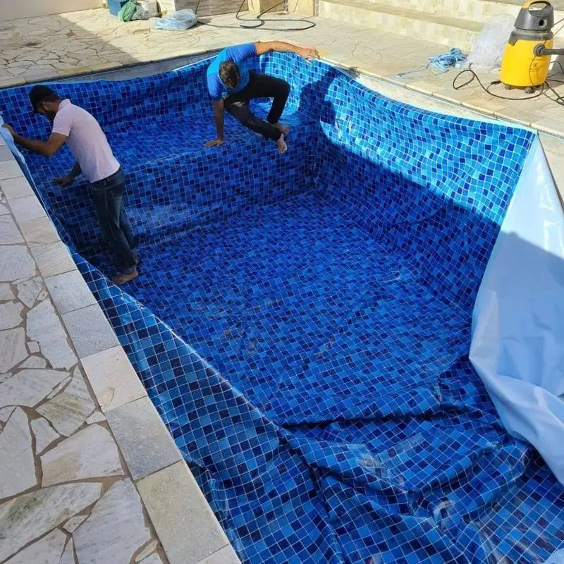 Equipe instalando revestimento em vinil dentro da piscina