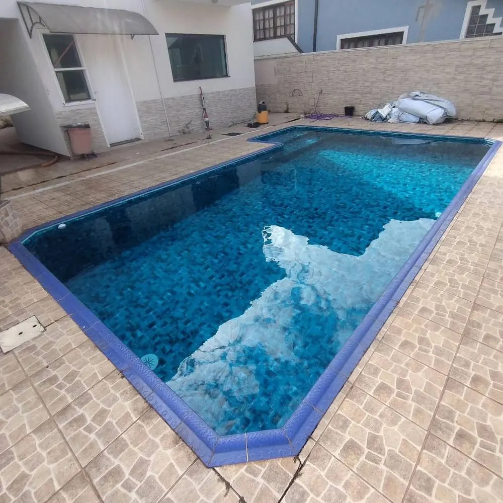 Piscina pronta com borda azul e revestimento em mosaico, obra em Itatiba